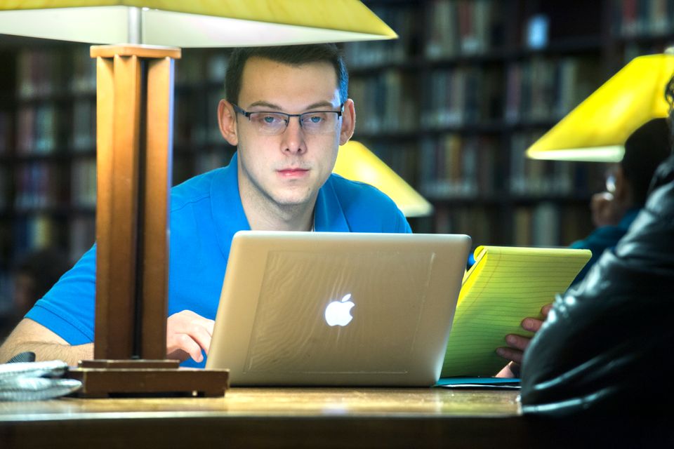 student studying in quiet reading room with computer